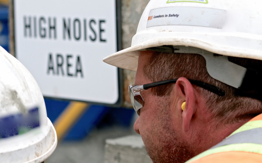 Construction Worker wearing personal protective hearing protection in a high noise area.